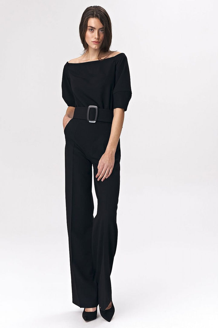 Elegant black women's suit featuring a cold-shoulder design that gracefully highlights the shoulders. A wide belt with a bold buckle cinches the waist for a flattering silhouette. Crafted from a soft viscose-blend fabric for superior comfort, this suit offers a chic and modern twist on traditional office wear.