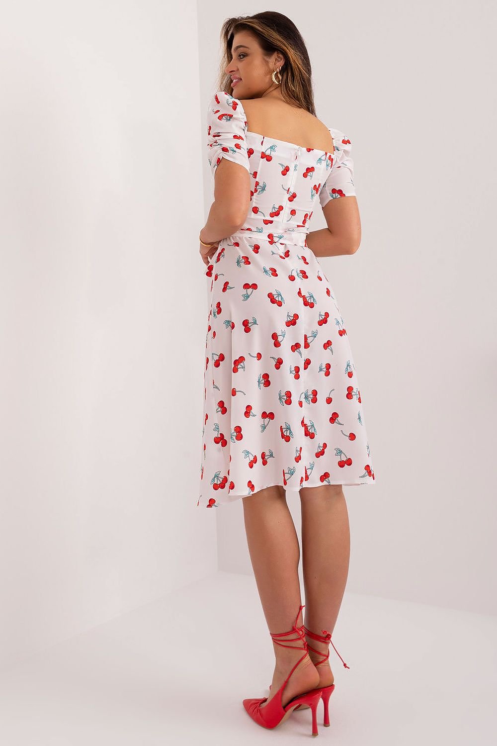 Flared summer youth dress featuring a cherry print, heart-shaped neckline, buff sleeves, tie belt, and discreet back zipper