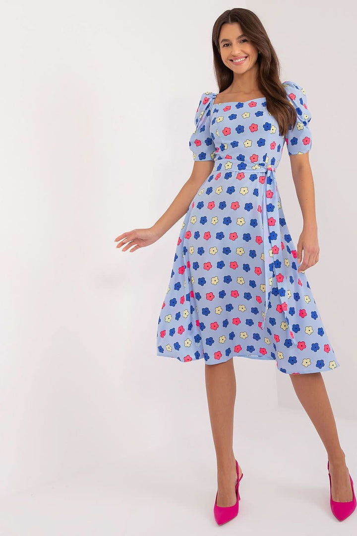 Flared summer youth dress featuring a colorful floral pattern, heart-shaped neckline, buff sleeves, tie belt, and discreet back zipper