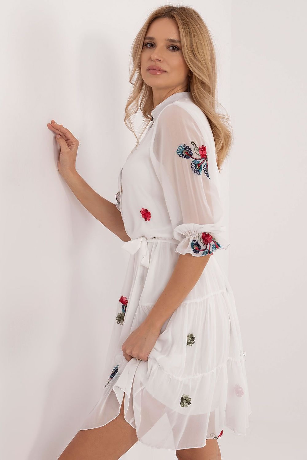 Elevate your style with this charming flared dress, designed to blend everyday comfort with timeless elegance. Crafted from a premium mix of cotton, elastane, and polyester, it offers a perfect fit and a soft feel. The embroidered fabric adds a unique touch, enhancing its subtle beauty. With a below-the-knee cut, 3/4-length sleeves, and a stand-up collar, this dress combines classic sophistication with a feminine silhouette. The partial button closure and tie belt at the waist ensure a flattering fit, while