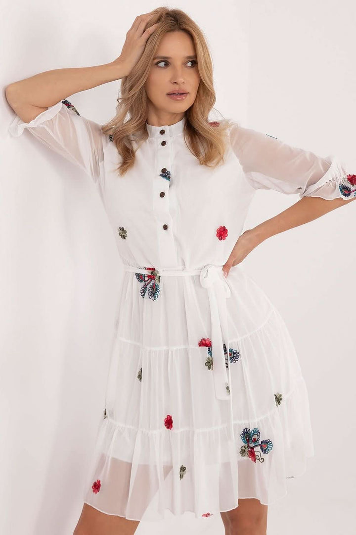 Elevate your style with this charming flared dress, designed to blend everyday comfort with timeless elegance. Crafted from a premium mix of cotton, elastane, and polyester, it offers a perfect fit and a soft feel. The embroidered fabric adds a unique touch, enhancing its subtle beauty. With a below-the-knee cut, 3/4-length sleeves, and a stand-up collar, this dress combines classic sophistication with a feminine silhouette. The partial button closure and tie belt at the waist ensure a flattering fit, while