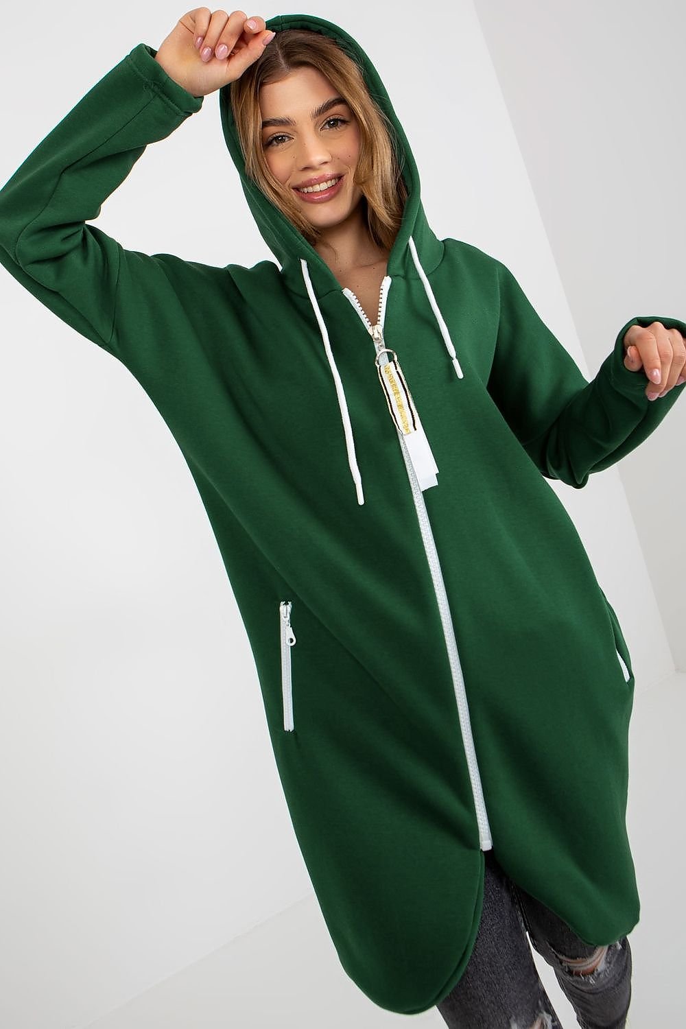 A women's  GREEN sweatshirt with an extended cut, long sleeves, a hood, and zippered side pockets. Perfect for casual wear, offering both style and practicality.






