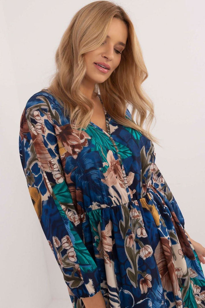 Stylish mini dress featuring a flared cut that beautifully shapes the silhouette, a heart neckline, and long sleeves. Made of airy polyester with a viscose lining, this dress offers comfort and a fresh floral print, perfect for warmer days and various occasions. Ideal for casual meetings and everyday wear, it combines ease and fashionable style.