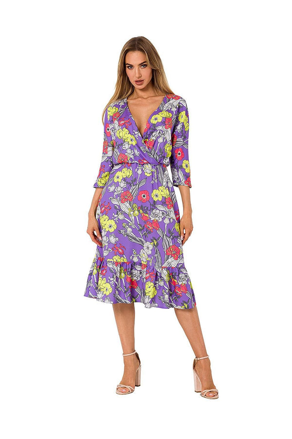 A back view of a vibrant purple midi dress featuring a floral print, 3/4 sleeves, a ruffled hem, and an elastic waistband for a flattering fit.

