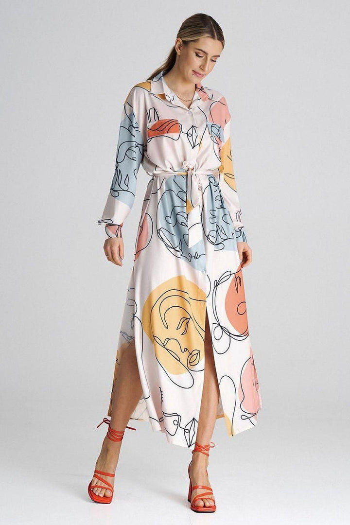 Maxi shirt dress with a collar. Decorative tabs on the bust line. Long sleeve finished with a buttoned cuff. Dress buttoned up, tied at the waist. Side slits. Dress without pockets and lining.