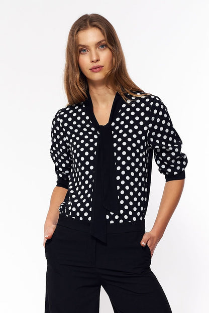 A charming women's blouse with colorful polka dots on the front, capturing the essence of 60s fashion. The back is plain, providing a sleek contrast. This blouse adds a playful, girlish touch to any office outfit or casual look.






