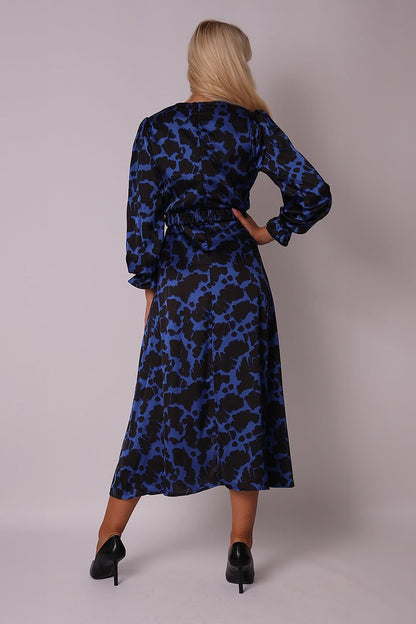 A cobalt-black midi dress featuring an envelope front, long sleeves with elastic cuffs, a belt with a gold buckle, and a concealed back zipper. Perfectly pairs with gold stilettos and accessories for an elegant look.






