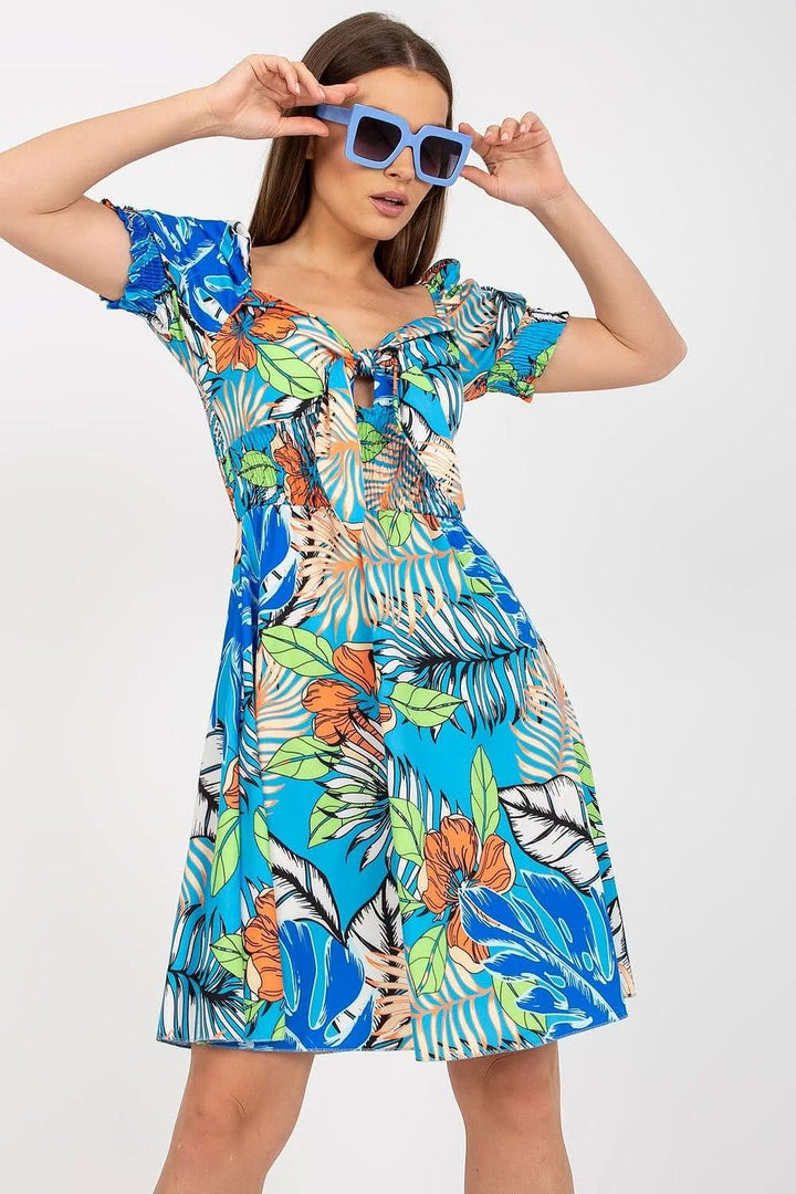 Summer dress with a Spanish-style neckline, tie front, short sleeves, sewn-in stiffening cups, and decorative pleats

