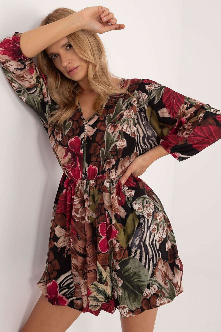 Stylish mini dress featuring a flared cut that beautifully shapes the silhouette, a heart neckline, and long sleeves. Made of airy polyester with a viscose lining, this dress offers comfort and a fresh floral print, perfect for warmer days and various occasions. Ideal for casual meetings and everyday wear, it combines ease and fashionable style.