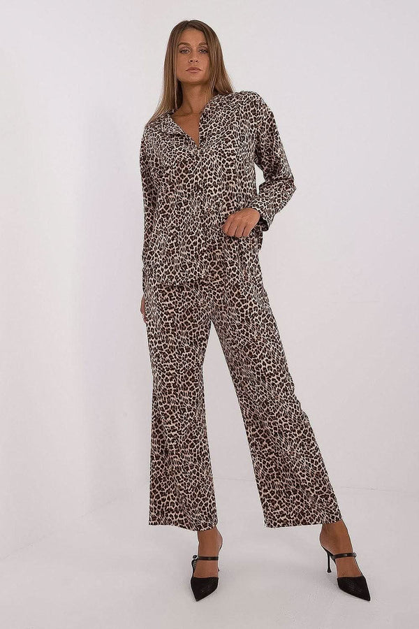  Elegant women's set featuring a button-up shirt with long sleeves, a collar, and a stylish animal print. Paired with high-waisted, wide-leg pants for comfort and freedom of movement. Made from a polyester-elastane blend, this outfit combines fashion, comfort, and a touch of bold style. Ideal for women seeking a predatory touch in their everyday wear.