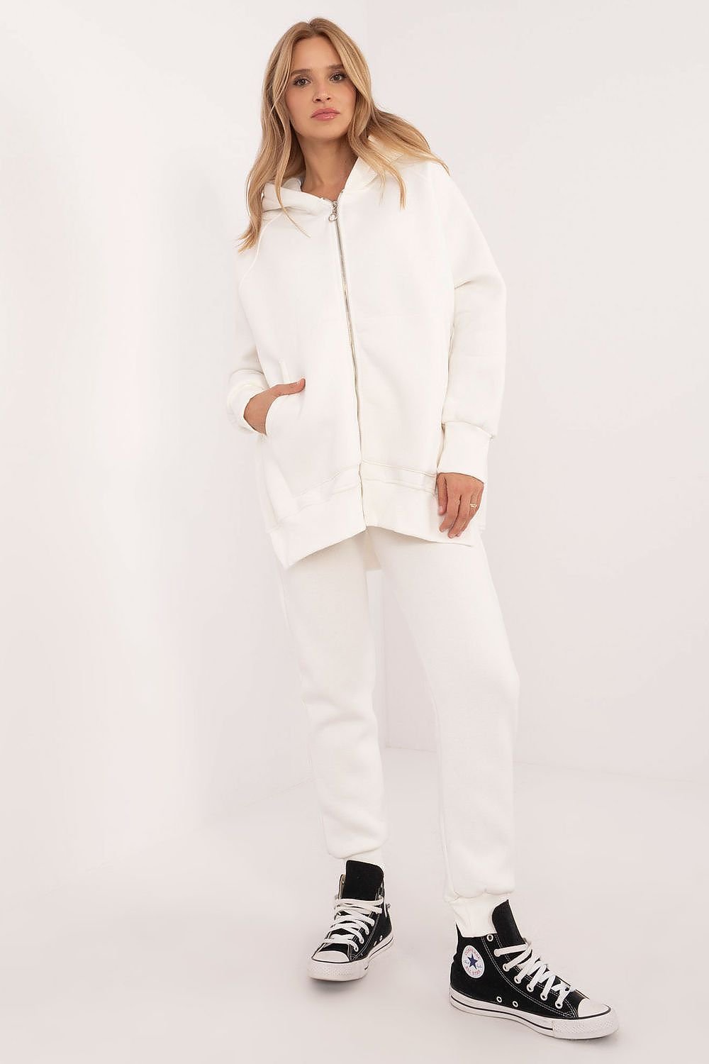 This stylish tracksuit set is perfect for everyday wear, consisting of a zippered sweatshirt and matching pants. Made from a cotton-elastane blend, it offers comfort, softness, and freedom of movement. The sweatshirt features long sleeves, front patch pockets, and a hood for extra warmth, while the pants have a high-rise waist, ribbed cuffs, and side slip pockets. The elastic waistband ensures a comfortable and secure fit. Whether you're running errands or relaxing at home, this set combines practicality, c