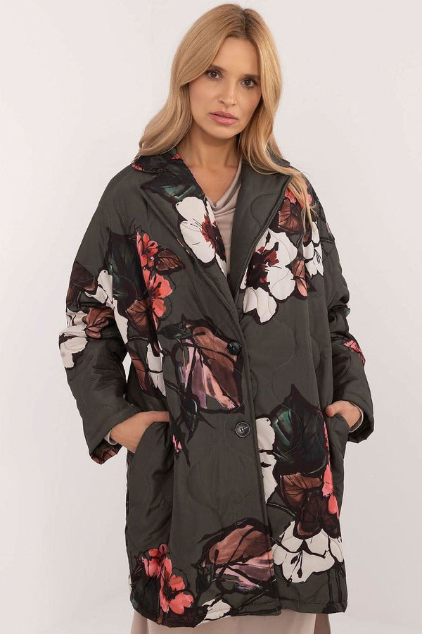 A stylish oversized brown quilted jacket for women, featuring bold floral patterns in orange, white, and green, with large buttons and a cozy, relaxed fit.






