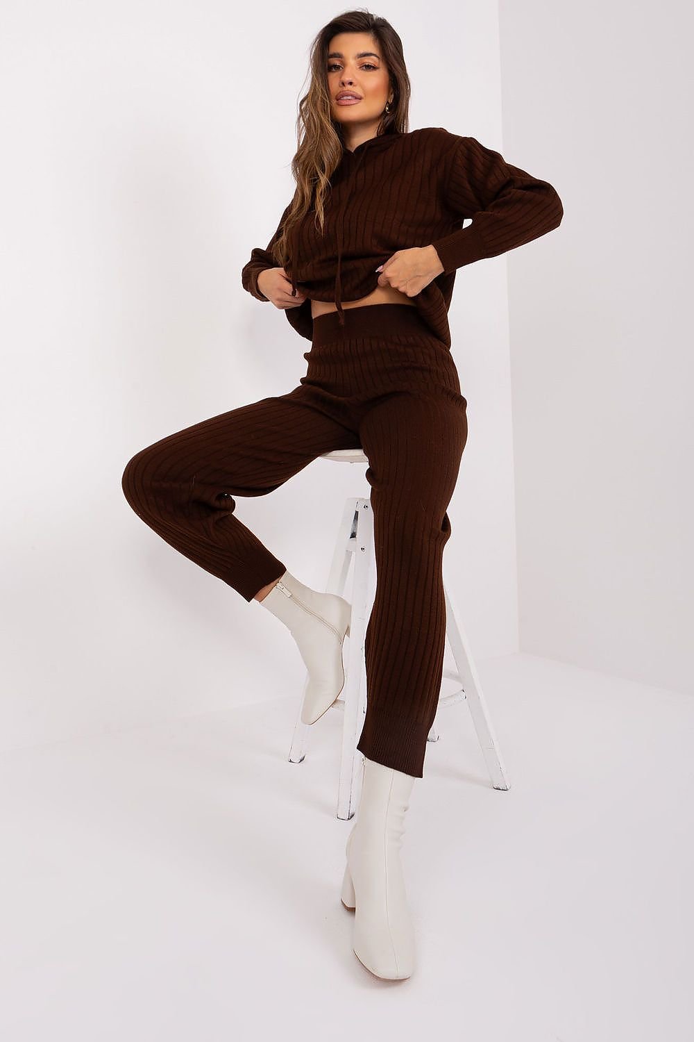 A casual and comfortable women's set featuring a long-sleeve hooded sweater and high-waisted pants with ribbed details, offering style and comfort for everyday wear.