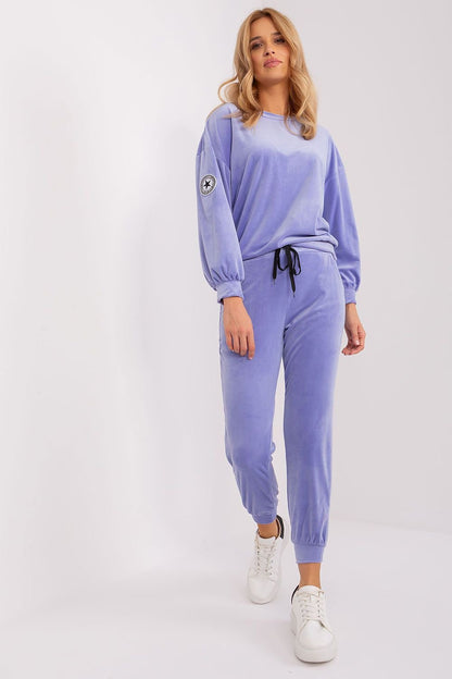 An elegant velour sweatshirt set featuring a round-neck, long-sleeve sweatshirt with a unique patch on one sleeve, paired with tapered pants with a drawstring waist and practical side pockets. Perfect for various occasions, offering a combination of comfort and chic style.






