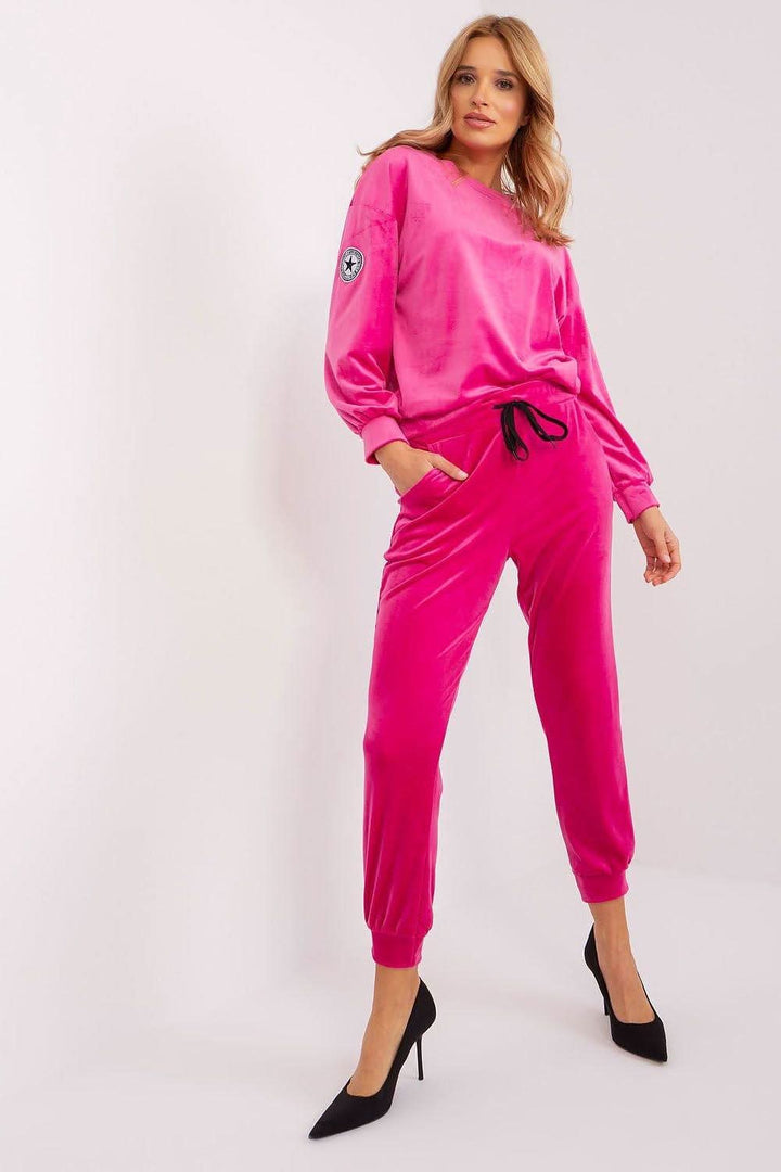 An elegant velour sweatshirt set featuring a round-neck, long-sleeve sweatshirt with a unique patch on one sleeve, paired with tapered pants with a drawstring waist and practical side pockets. Perfect for various occasions, offering a combination of comfort and chic style.






