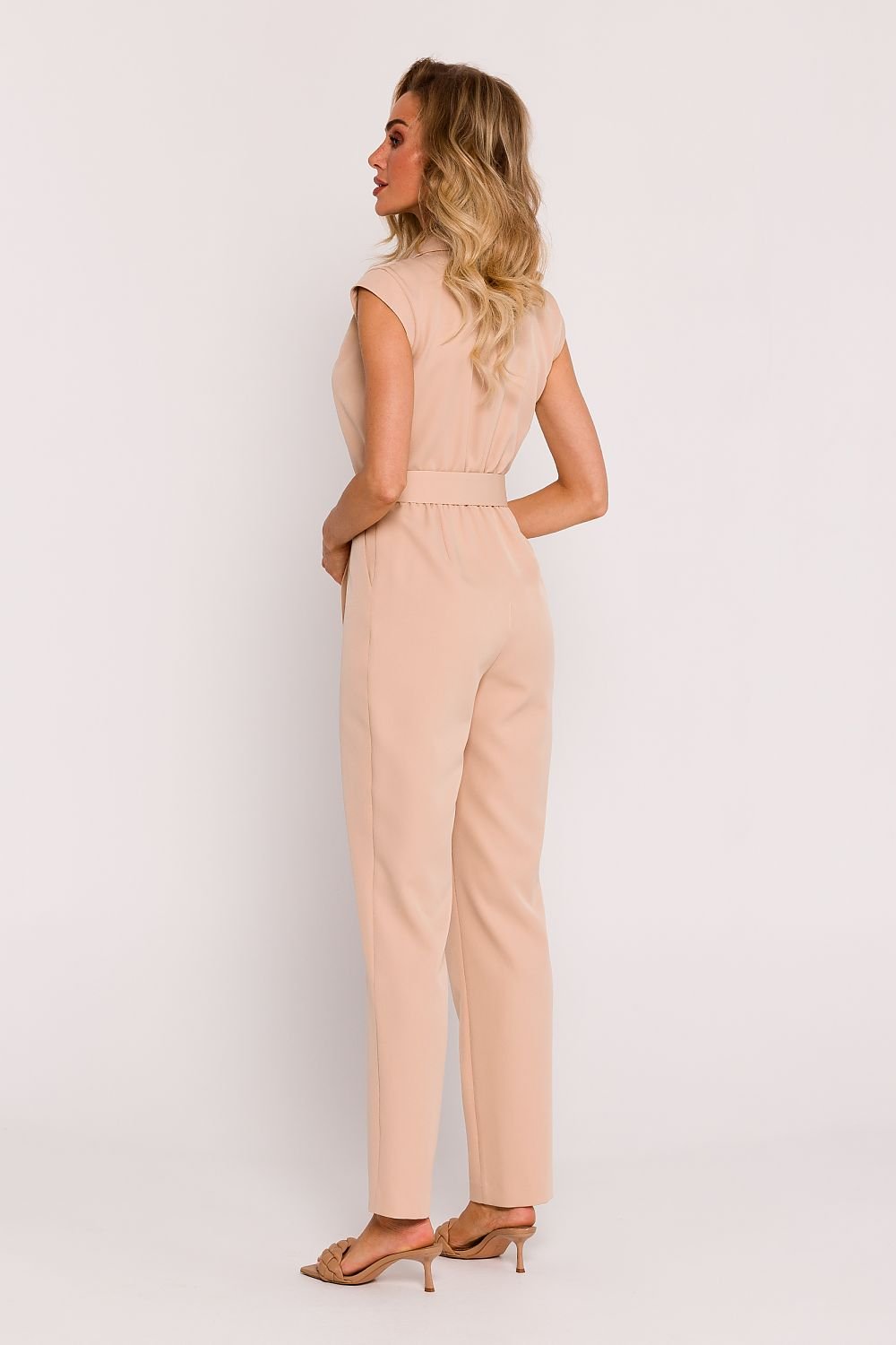 Elegant sleeveless jumpsuit featuring tapered legs with side asymmetry, a V-neck envelope top with a collar, press-stud and covered zipper front, elastic back waistband, side pockets, and a buckled belt for a stylish, comfortable fit.






