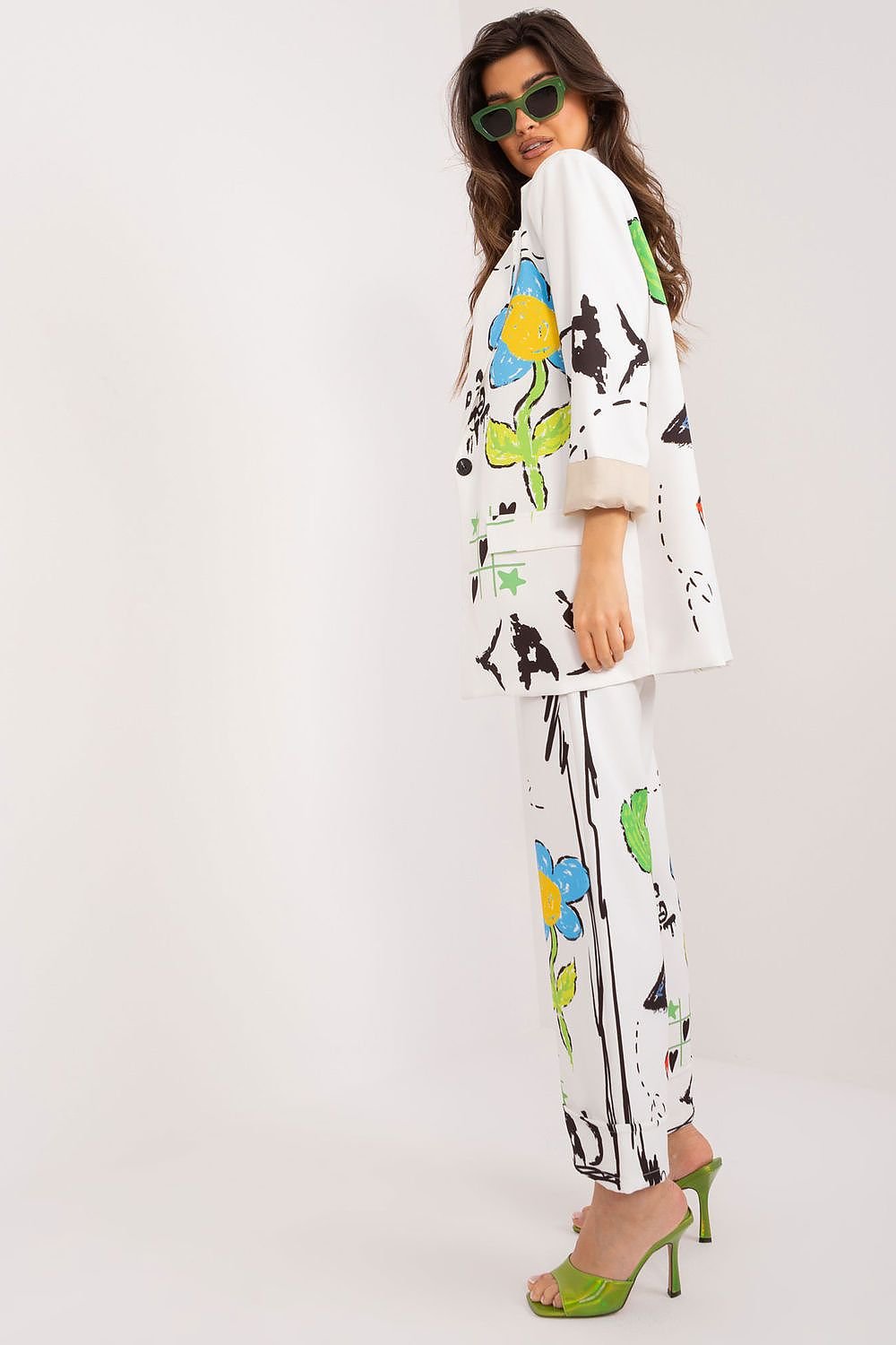  A sophisticated women's set featuring a buttoned jacket with long sleeves and lapels, paired with high-waisted, straight-leg pants with a zipper and button closure, all adorned with a vibrant print for a stylish and versatile look.