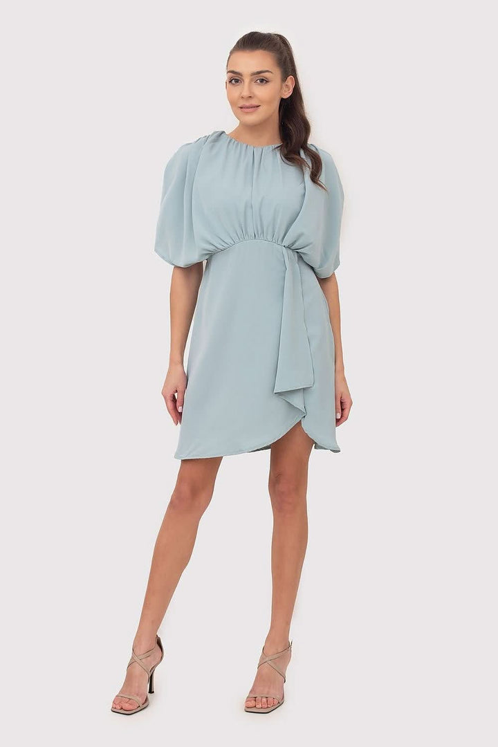 A mint-colored summer mini dress made of flowing fabric, featuring decorative creases, wide sleeves, and an elastic waistband, perfect for a variety of occasions.






