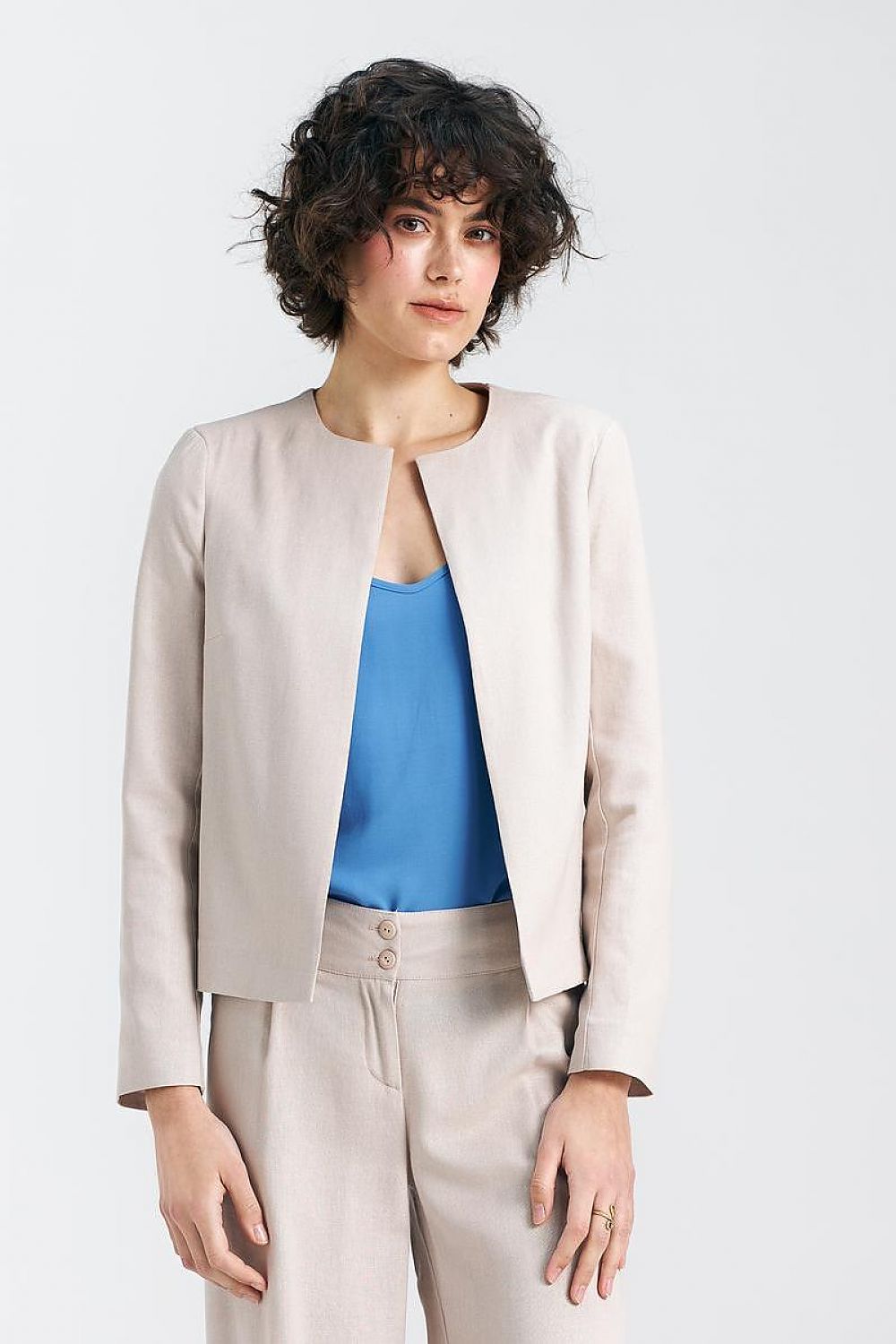 An elegant boxy jacket featuring shoulder cushions that enhance structure and sophistication. This jacket offers a modern, short form, made from a blend of high-quality materials for comfort and style. With no traditional clasp, it provides a lightweight and contemporary look, perfect for those who value refined design and craftsmanship.