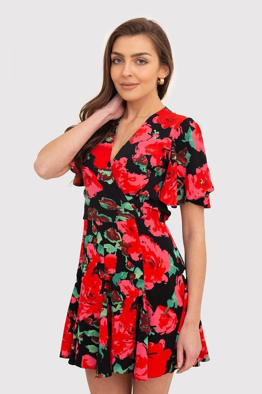 A red draped dress with a floral print, featuring short ruffled sleeves, an envelope-style top, and a skater bottom. The dress fastens with a covered zipper, combining elegance with a playful touch. Perfect for a variety of occasions.






