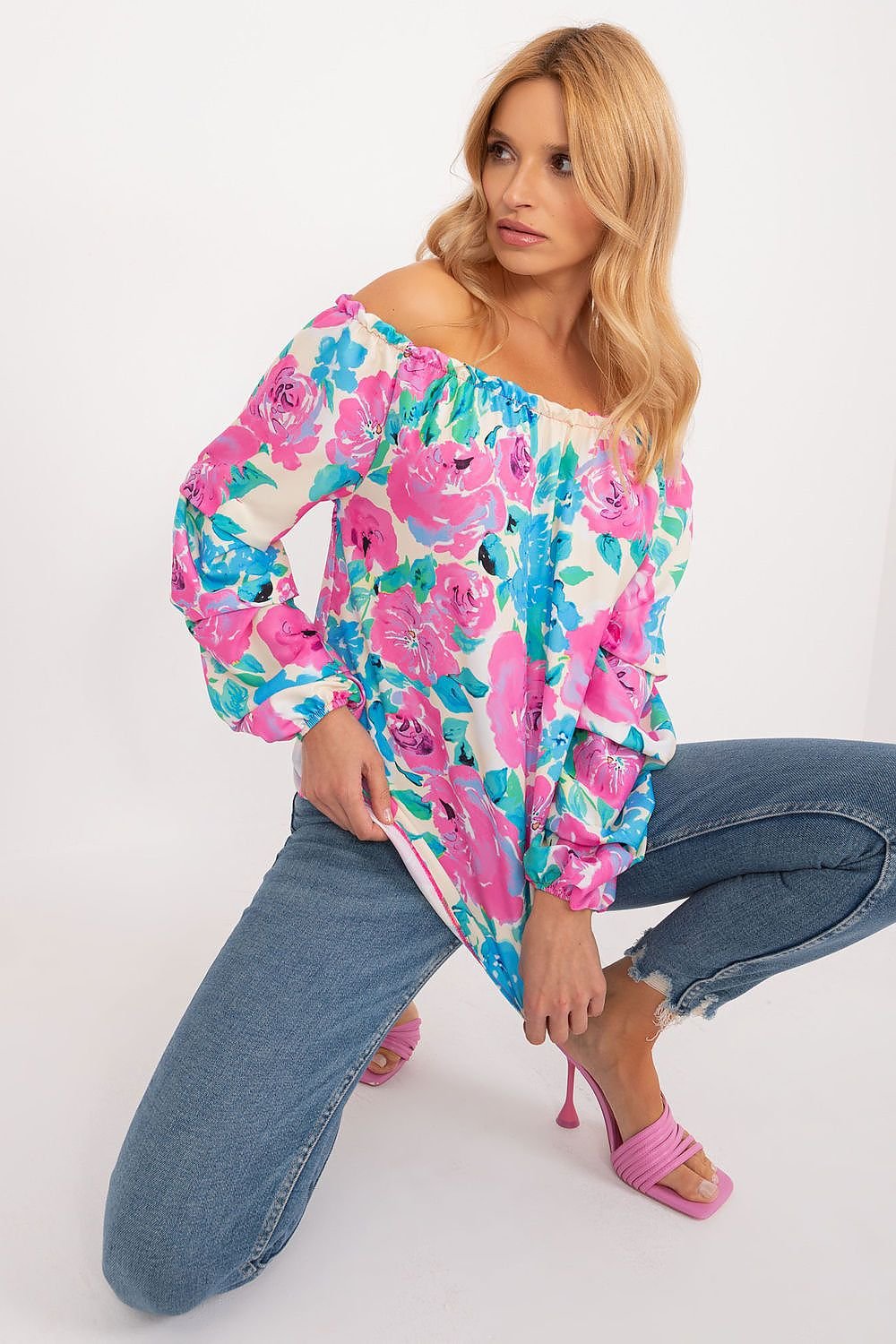 Colorful floral blouse with long buff sleeves, Spanish-style neckline, and elegant creases, perfect for a fresh and stylish summer look.