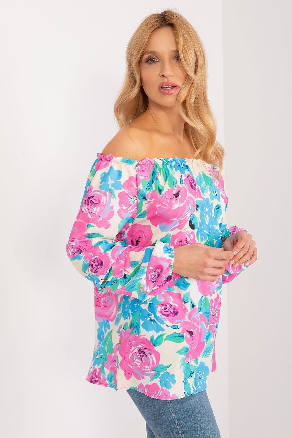 Colorful floral blouse with long buff sleeves, Spanish-style neckline, and elegant creases, perfect for a fresh and stylish summer look.