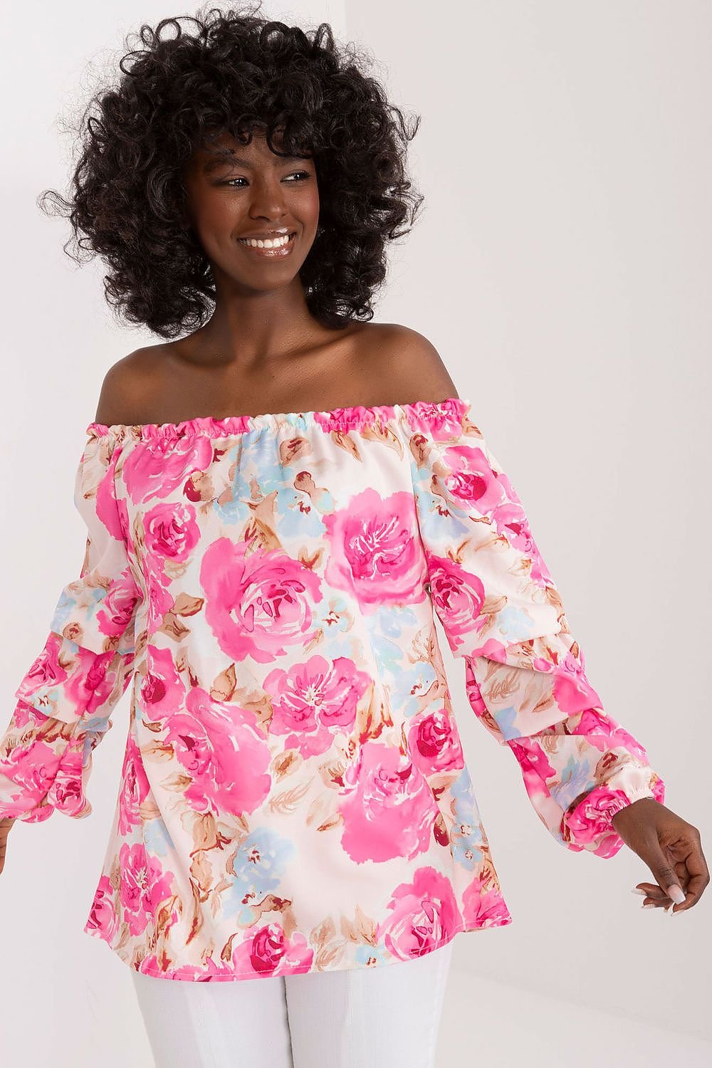 Colorful floral blouse with long buff sleeves, Spanish-style neckline, and elegant creases, perfect for a fresh and stylish summer look.