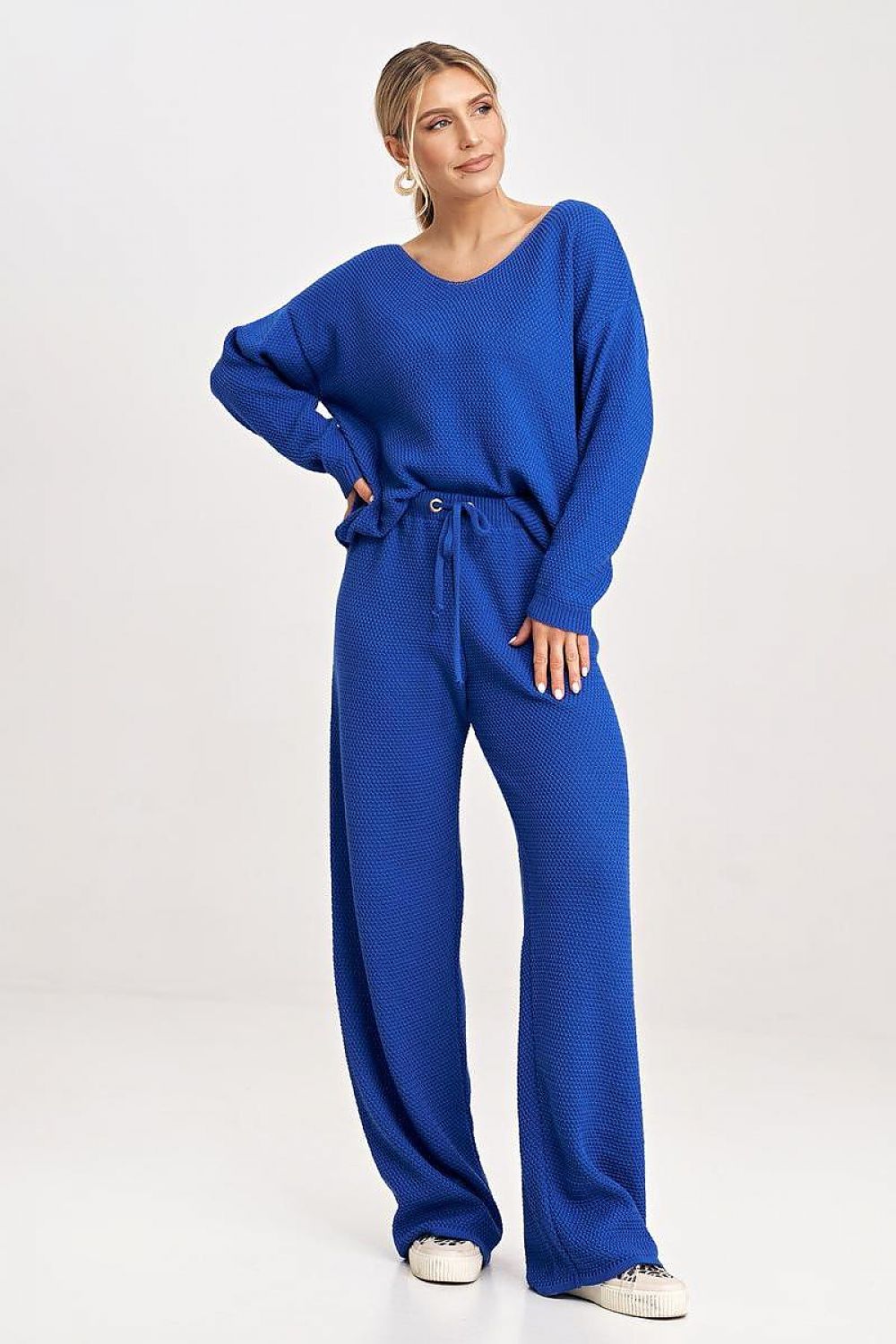 A comfortable blue set featuring a long-sleeve blouse with a wide neckline, paired with loose-fitting long pants with a tie at the waist for an adjustable and relaxed fit.






