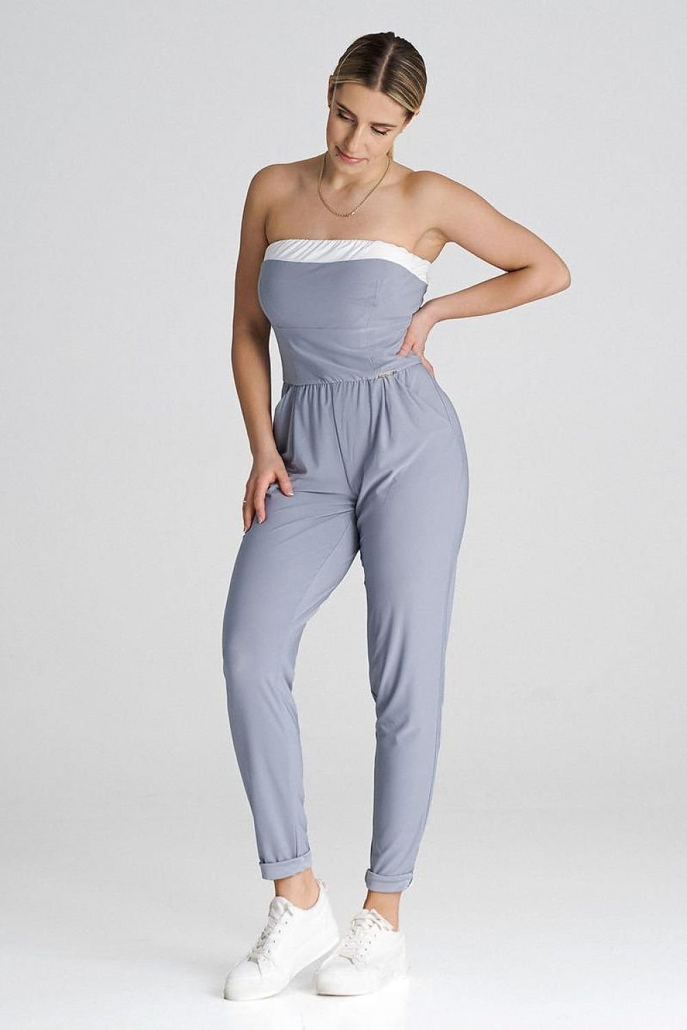 Elegant loose-fitting jumpsuit featuring a strapless top with a contrasting insert, long pleated legs, and slide pockets for a classic yet modern style.






