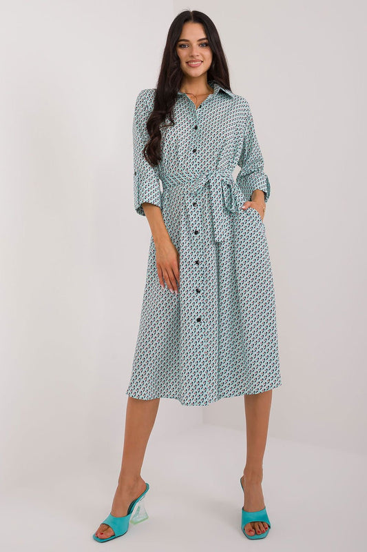 A versatile shirt dress with a flared cut, midi length, and 3/4 sleeves, featuring a muted print, tie belt, buttons, and practical slip pockets, perfect for everyday wear and work.






