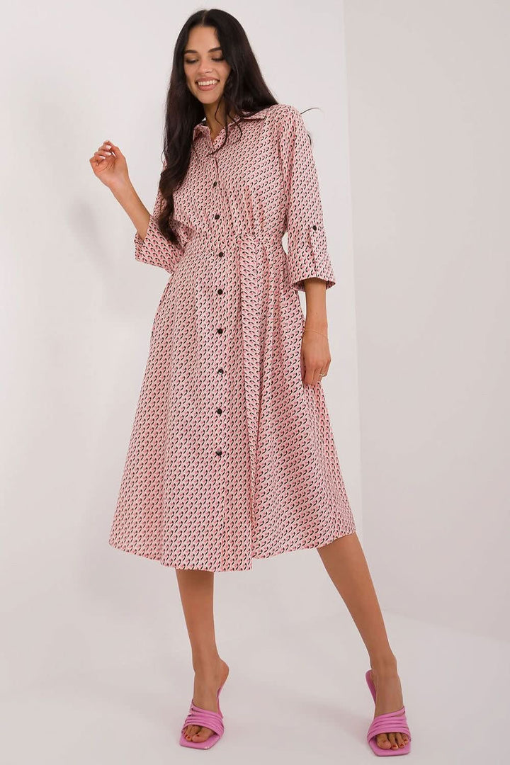 A versatile shirt dress with a flared cut, midi length, and 3/4 sleeves, featuring a muted print, tie belt, buttons, and practical slip pockets, perfect for everyday wear and work.






