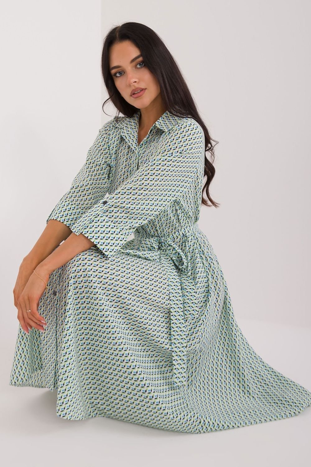 A versatile shirt dress with a flared cut, midi length, and 3/4 sleeves, featuring a muted print, tie belt, buttons, and practical slip pockets, perfect for everyday wear and work.






