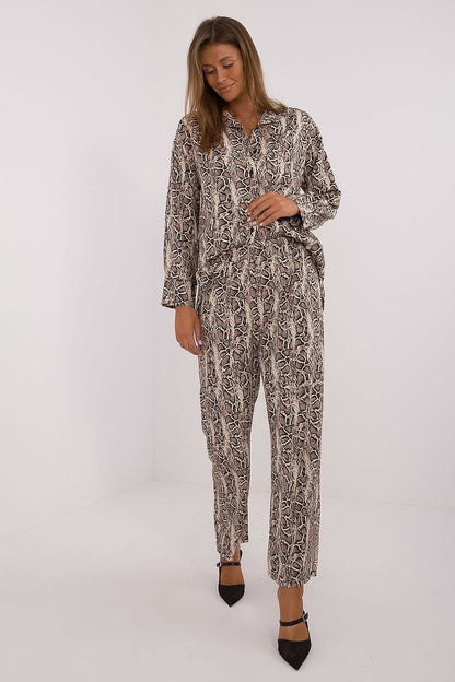  Elegant women's set featuring a button-up shirt with long sleeves, a collar, and a stylish animal print. Paired with high-waisted, wide-leg pants for comfort and freedom of movement. Made from a polyester-elastane blend, this outfit combines fashion, comfort, and a touch of bold style. Ideal for women seeking a predatory touch in their everyday wear.