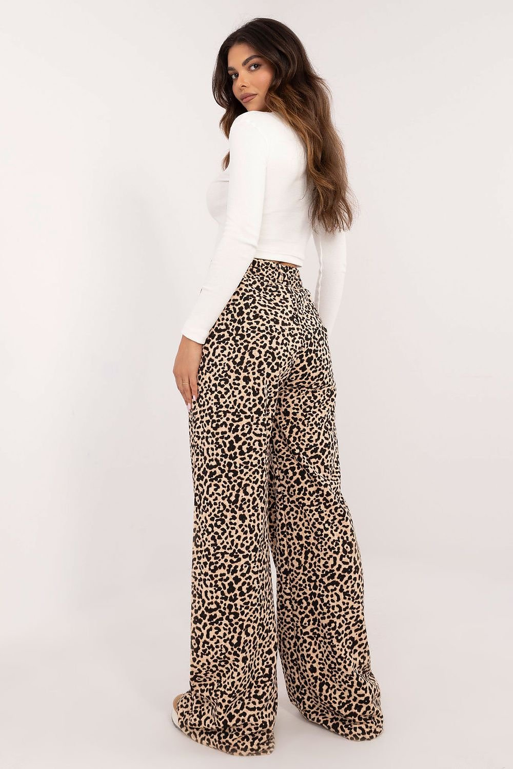 A casual women's set featuring a ribbed long-sleeve blouse with a round neckline and subtle front inscription, paired with high-waisted pants with wide legs and an animal print motif, combining comfort and bold style for everyday wear.