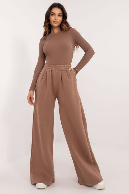 Stylish women's set made from a cotton-elastane blend, featuring a short ribbed blouse with long sleeves for elegance and comfort. Paired with wide, long-legged pants with a high rise, elastic waistband, and side slip pockets for practicality. The warming fabric makes this set perfect for colder days, offering a simple yet stylish look for everyday wear.