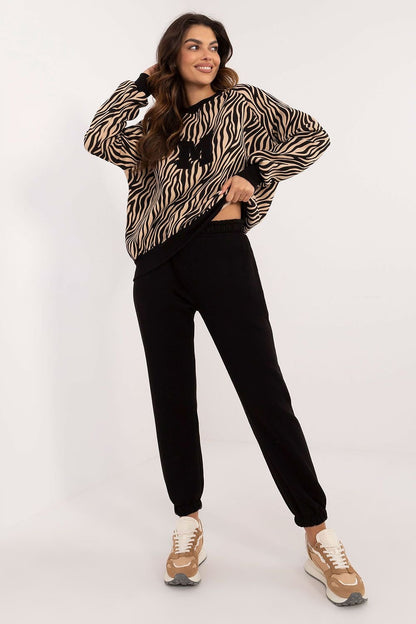  A casual women's set featuring a long-sleeve blouse with a round neckline and decorative patch, paired with high-waisted pants with slip pockets, offering comfort and style with an animal print sweatshirt design.