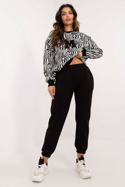  A casual women's set featuring a long-sleeve blouse with a round neckline and decorative patch, paired with high-waisted pants with slip pockets, offering comfort and style with an animal print sweatshirt design. LETTER M