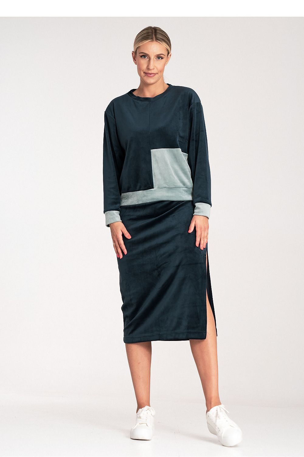 A women's velour set featuring a two-tone blouse with long sleeves and a round neckline, paired with a pencil skirt with a side slit and wide elastic waistband. Unlined for a relaxed fit and stylish look.






