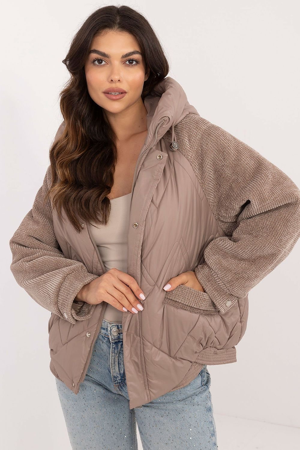 A fashionable women's casual jacket with striking corduroy sleeves, perfect for everyday outings in the autumn-winter season. Made of durable polyester, it features a smooth pattern, decorative quilting, and a standard length. Equipped with a hood, zipper and snap fastening, zippered slip pockets, and a lined interior, it's an ideal lighter option for cooler days.






