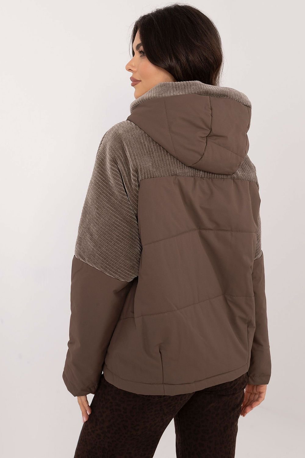 A casual women's transitional quilted jacket made from durable polyester, perfect for autumn-winter outings. Featuring a hood for protection from wind and light rain, zippered slip pockets, and a zipper and snap fastening for comfort. The smooth pattern and lightweight design make it ideal for the transitional seasons, offering both style and functionality.