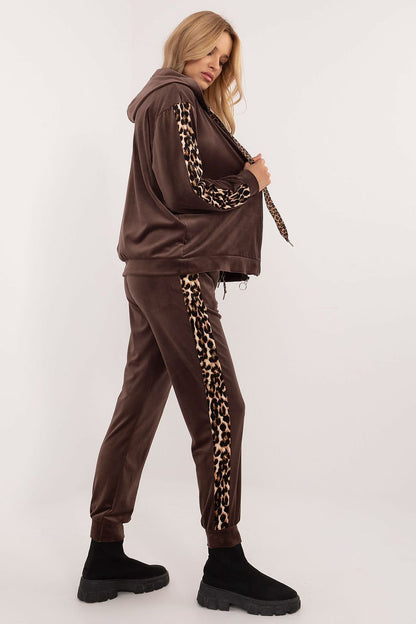 A women's velour set featuring a zippered sweatshirt with long sleeves, a hood, and leopard-patterned stripes on the sleeves. Paired with high-waisted pants tied at the waist, featuring slip-in side pockets and animal-patterned piping on the legs for a stylish, sporty look. Ideal for casual everyday wear.






