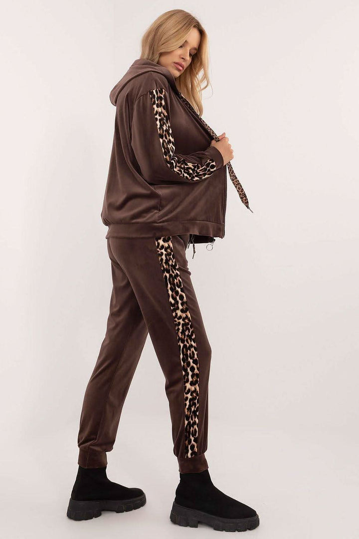 A women's velour set featuring a zippered sweatshirt with long sleeves, a hood, and leopard-patterned stripes on the sleeves. Paired with high-waisted pants tied at the waist, featuring slip-in side pockets and animal-patterned piping on the legs for a stylish, sporty look. Ideal for casual everyday wear.







