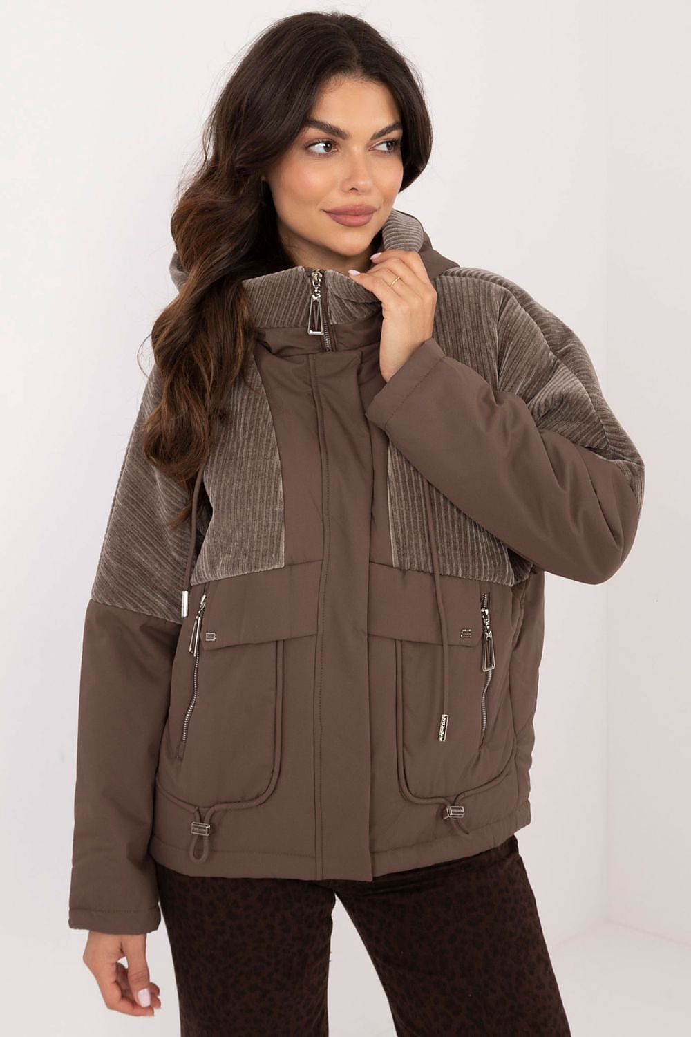 A casual women's transitional quilted jacket made from durable polyester, perfect for autumn-winter outings. Featuring a hood for protection from wind and light rain, zippered slip pockets, and a zipper and snap fastening for comfort. The smooth pattern and lightweight design make it ideal for the transitional seasons, offering both style and functionality.