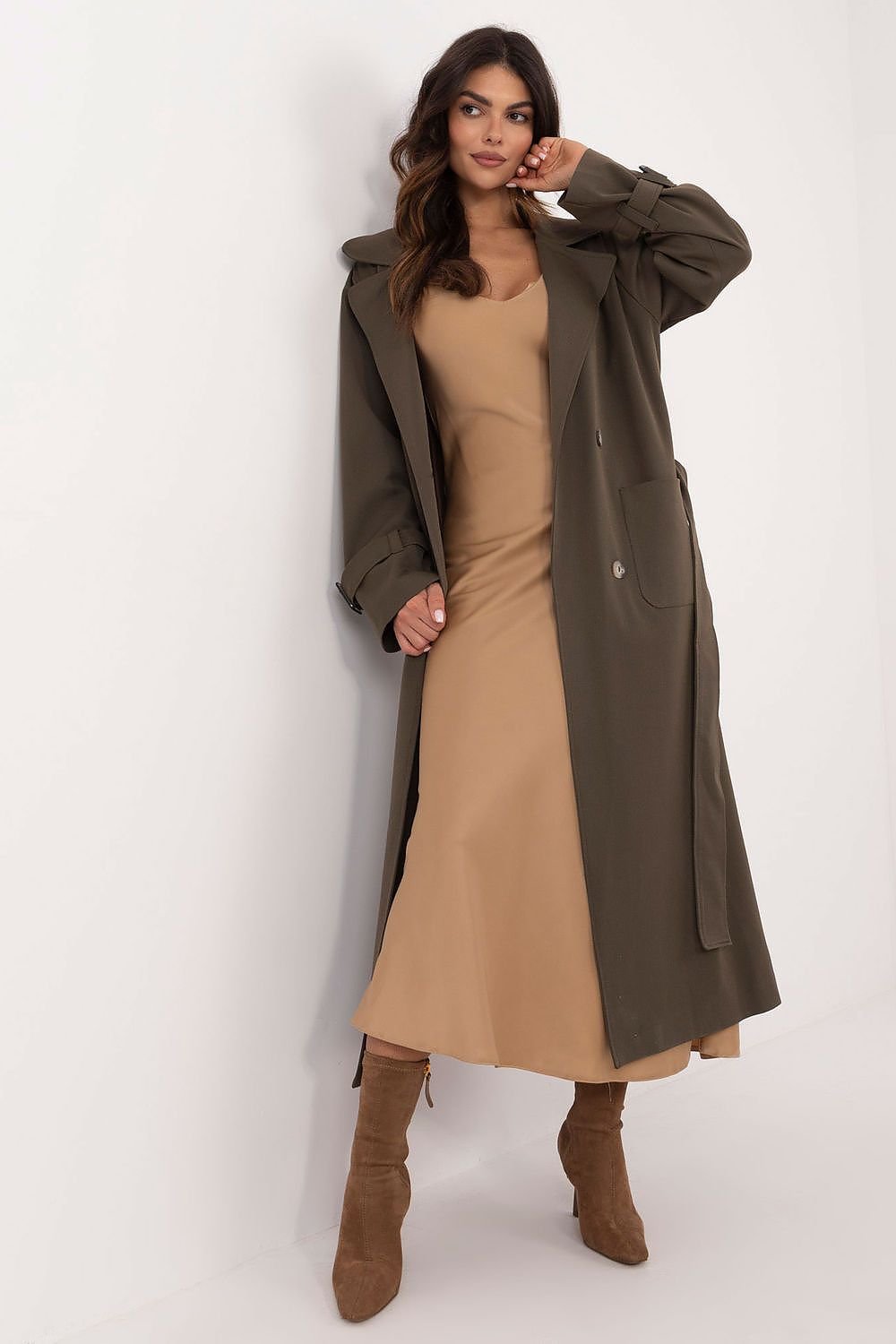 Elegant calf-length trench coat with double-breasted button closure, tie belt, slide-in pockets, and lined lapels. Perfect for transitional seasons.






