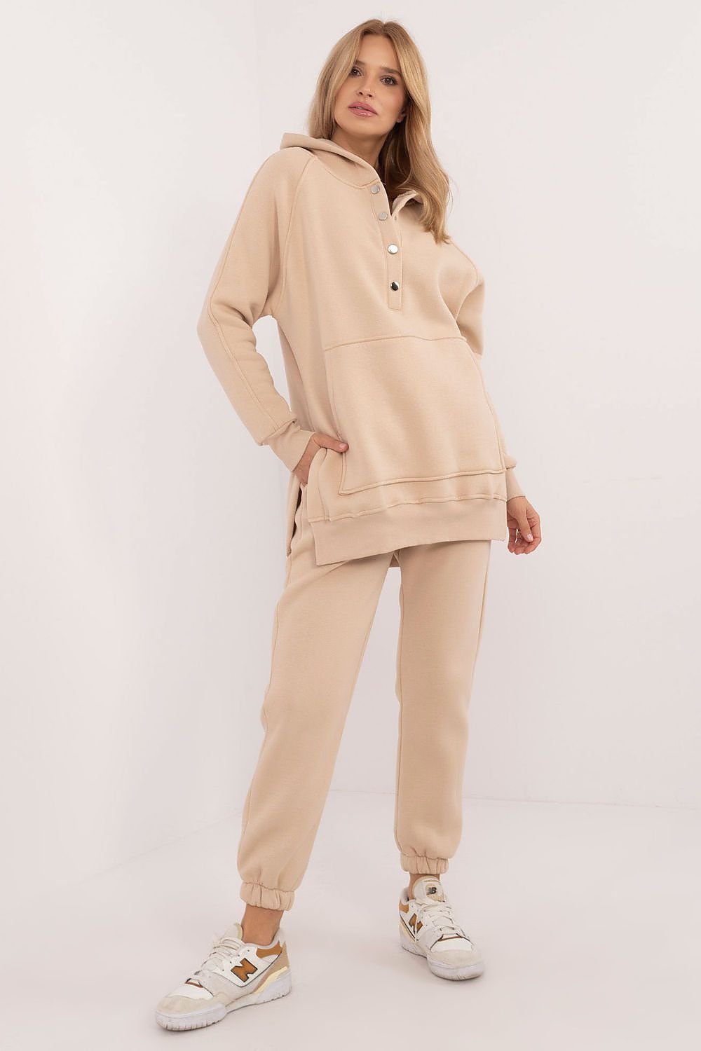 A cozy women's set featuring a mélange-patterned T-shirt, a long-sleeve sweatshirt with a hood and press-stud fastening, and high-waisted pants with ribbed cuffs, offering comfort and style for colder days and everyday outings.