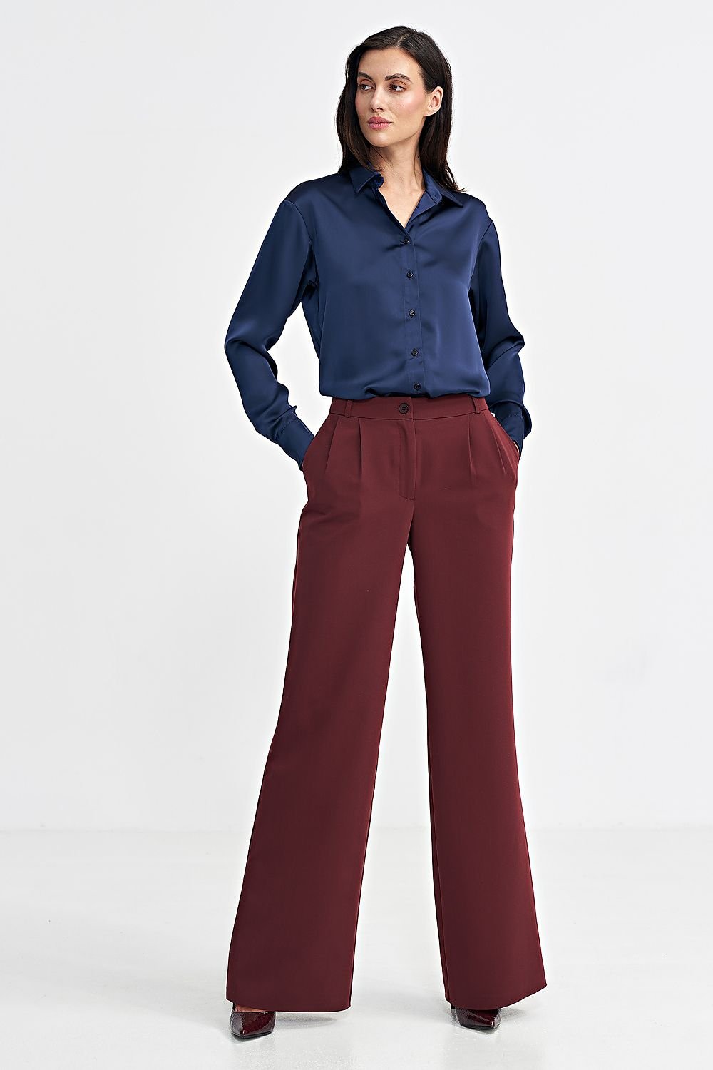 Women's relaxed fit pants with a mid-rise, decorative front pleats, and wide legs for a stylish yet comfortable look. Featuring a zip and button front, classic front pockets, imitation back pockets, and belt loops for versatility and functionality. Perfect for various occasions.






