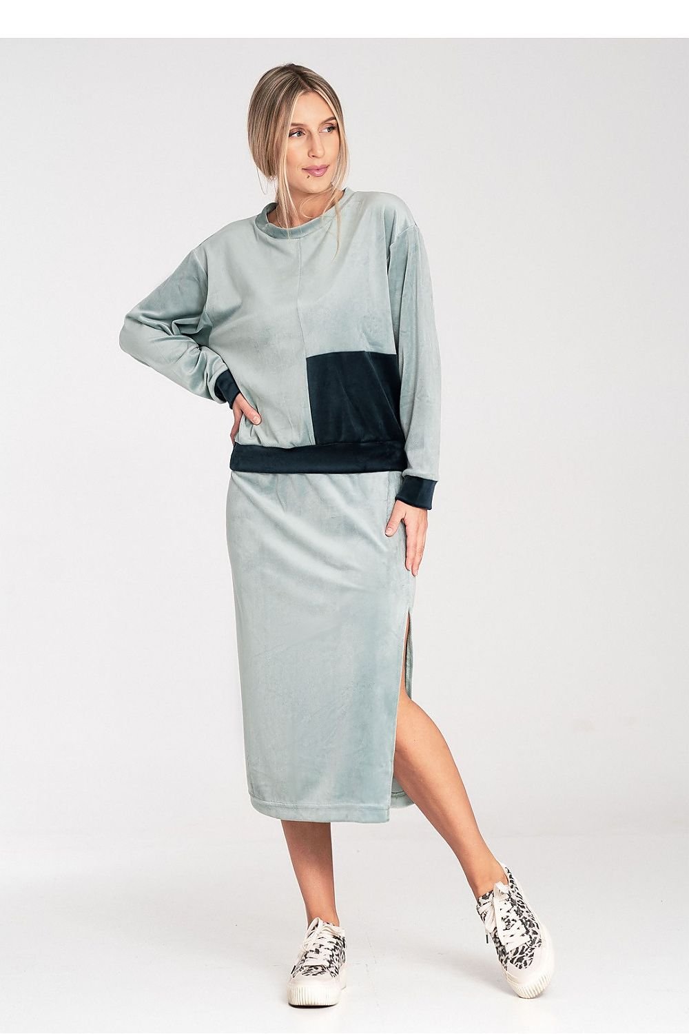 A women's velour set featuring a two-tone blouse with long sleeves and a round neckline, paired with a pencil skirt with a side slit and wide elastic waistband. Unlined for a relaxed fit and stylish look.






