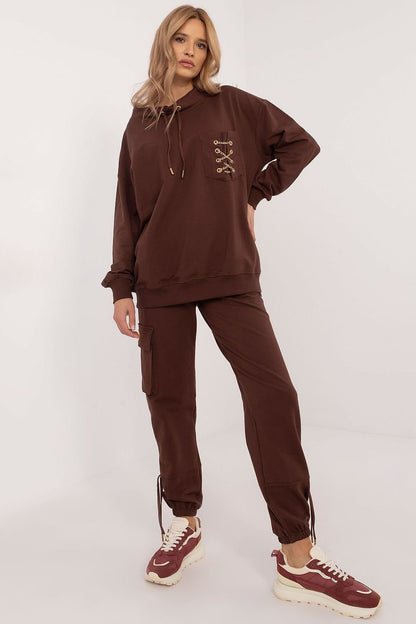 Trendy women's tracksuit set made from high-quality cotton with a touch of elastane for comfort and flexibility. The hoodie features a round neckline, front pocket with a chic chain detail, and the high-waisted pants have slip pockets and cuffs for a perfect fit. The smooth pattern makes it versatile and easy to style for any occasion. Ideal for women seeking comfort and style.