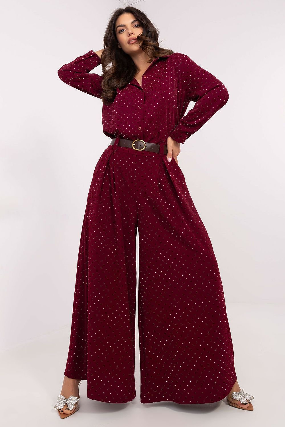 Elegant women's palazzo pants made from a high-quality blend of polyester and viscose, featuring subtle sequins, a high waist, and wide legs for a light, refined look. Practical inset side pockets and a fastened belt ensure a perfect fit, ideal for formal outings or special occasions.






