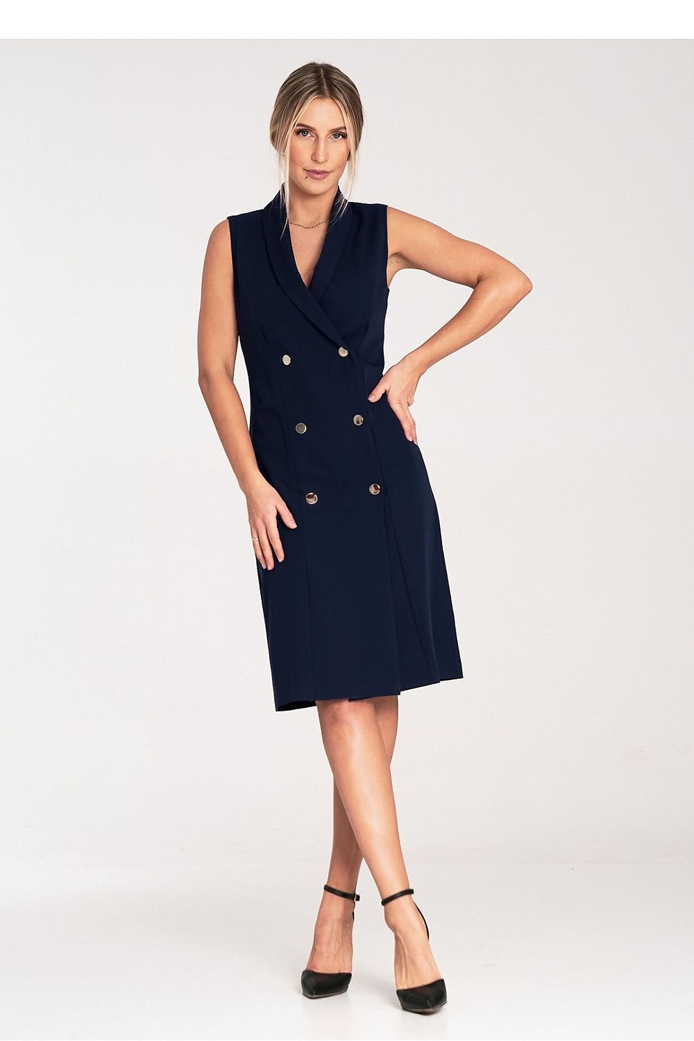 An elegant sleeveless midi dress with narrow lapels, an envelope neckline, a double-breasted closure featuring large decorative snaps, and a slightly flared hem.






